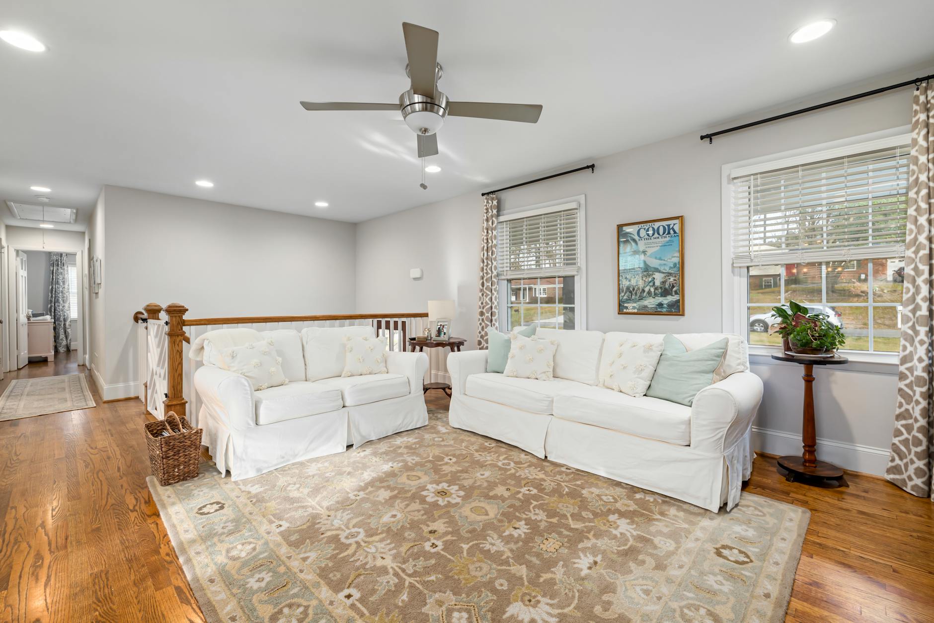 Jasny salon z białymi sofami i drewnianą podłogą