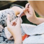 Kobieta szydełkuje na dworze, zbliżenie na fakturę robótki