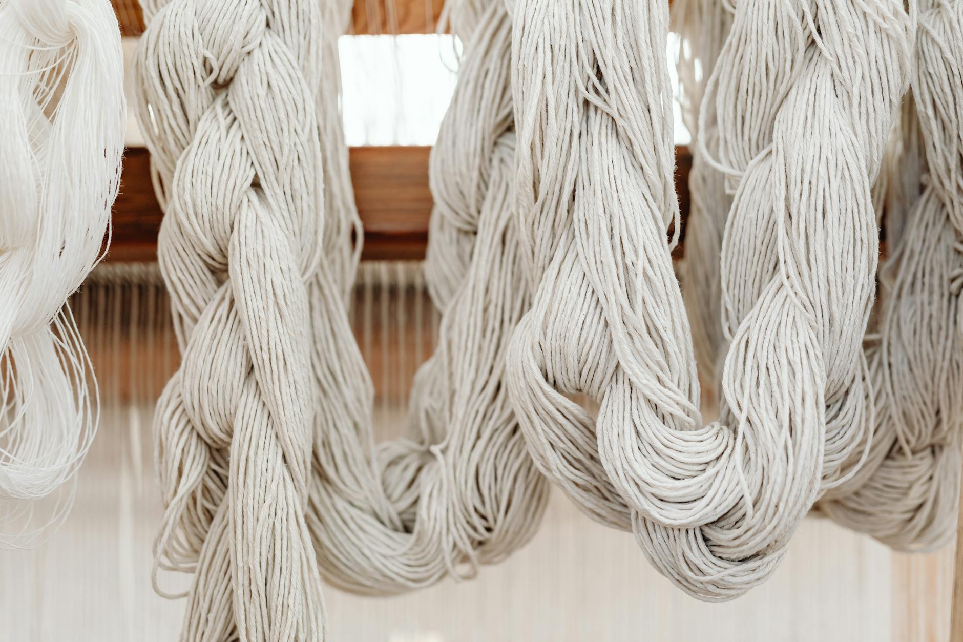 Poduszki plecione ze sznurka – jak uzyskać efektowną strukturę bez skomplikowanych wzorów Zbliżenie na plecione ze sznurka pasma na krośnie tkackim