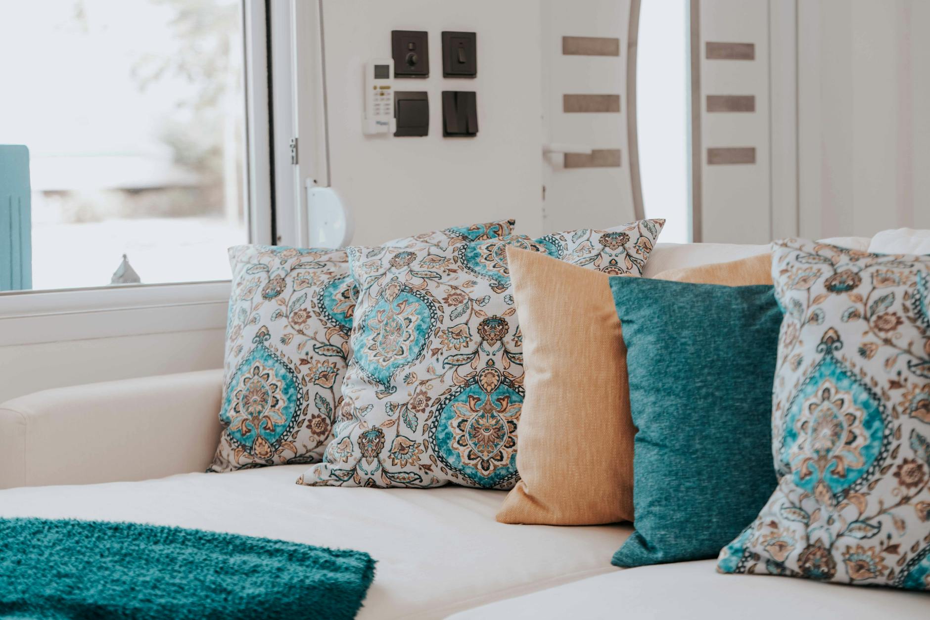 Nowoczesna sofa z miksowanymi poduszkami wzorzystymi i gładkimi